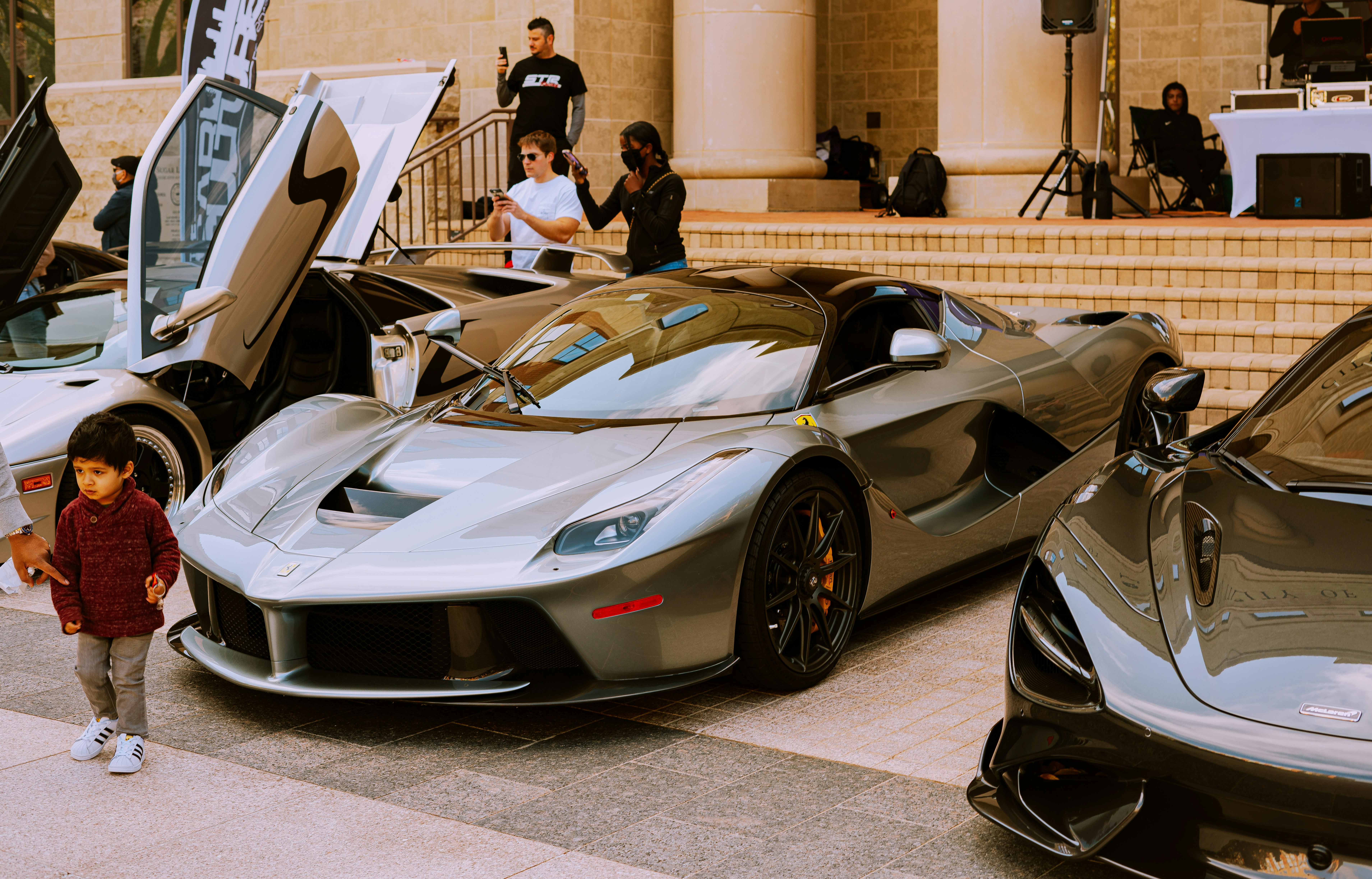 man in black jacket standing beside white lamborghini aventador